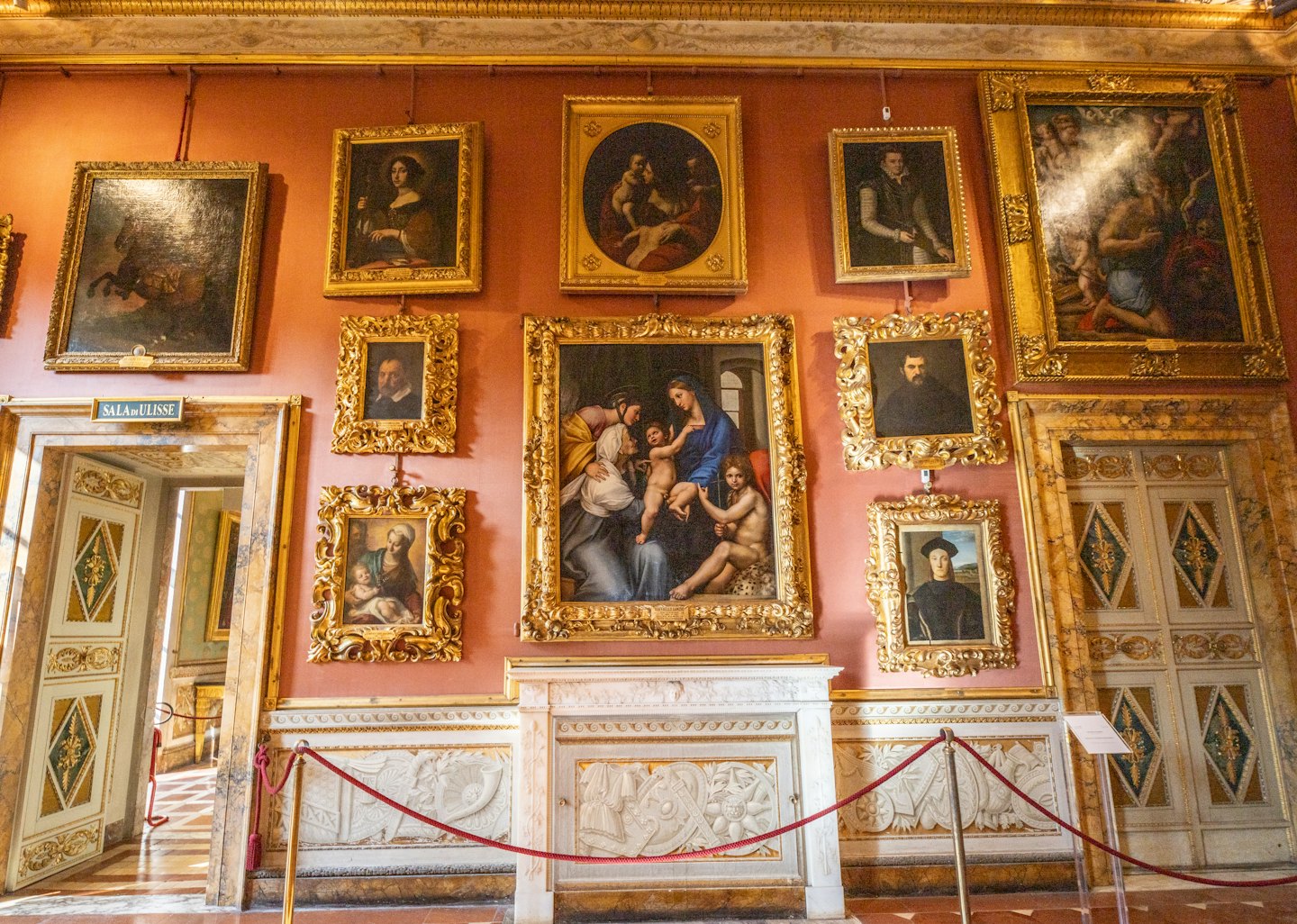 Klassieke Europese schilderijen hangen aan een museummuur met gouden lijsten.